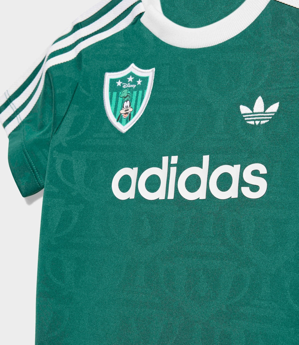 חולצת ספורט ירוקה עם שרוול קצר, לוגו adidas וסמל עם דמות מצוירת על החזה