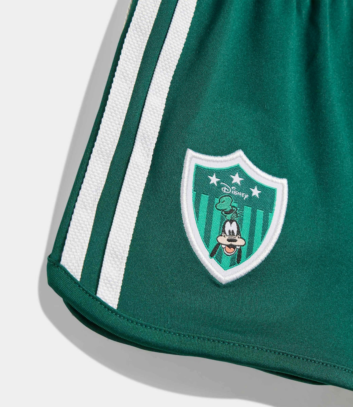 מכנסיים קצרים ירוקים עם שני פסים לבנים וסמל דמות דיסני מצוירת