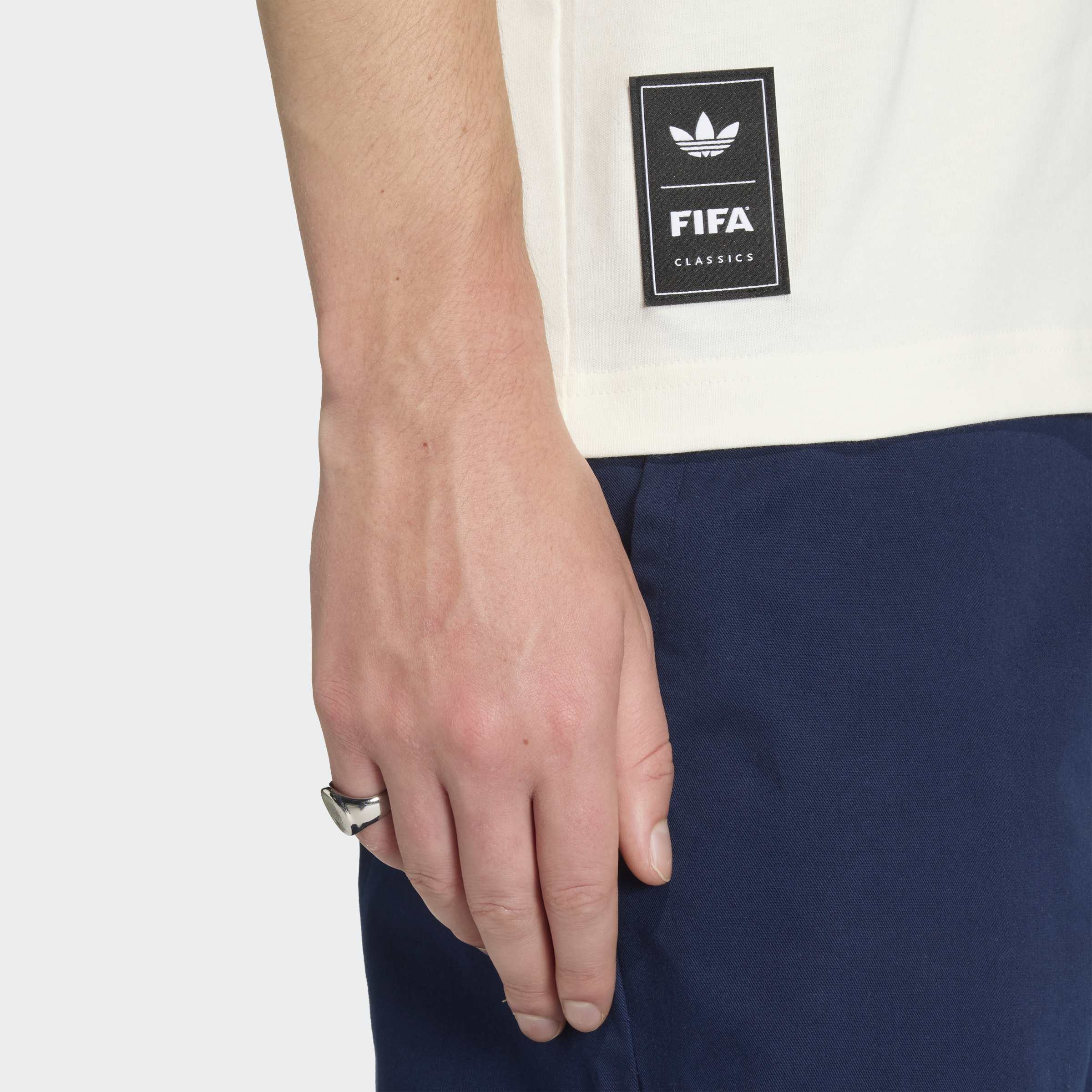 חולצת טי לבנה עם תג FIFA ושורטס כחולים, תצוגת דגם מקרוב