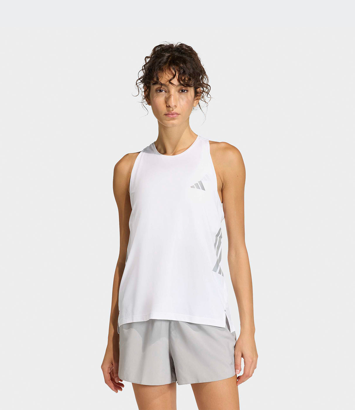 דוגמנית לובשת חולצת ספורט לבנה ומכנסיים קצרים אפורים, רקע לבן, אופנת נשים