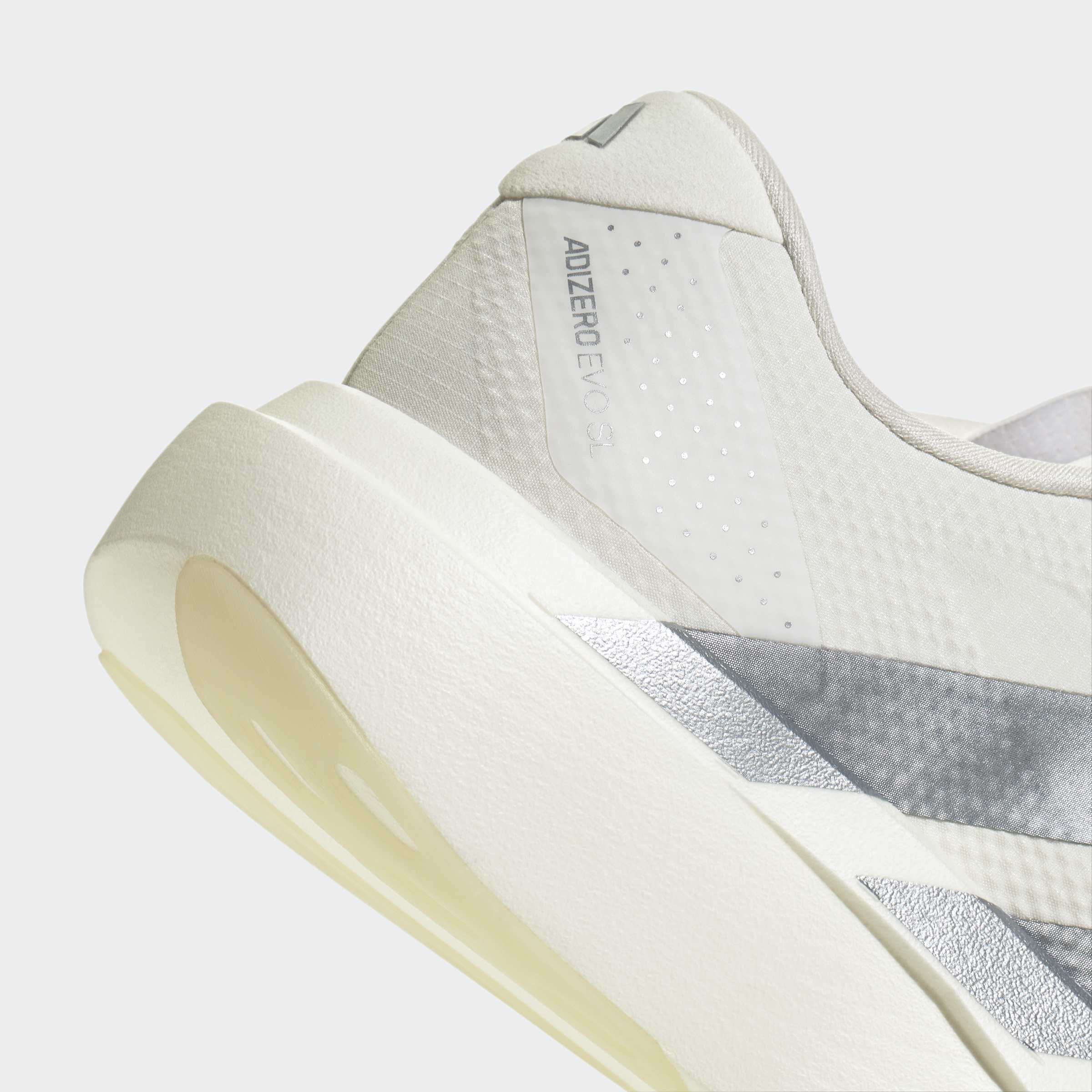 תקריב נעל ספורט ריצה בצבעים לבן ואפור עם כיתוב ADIZERO EVO SL