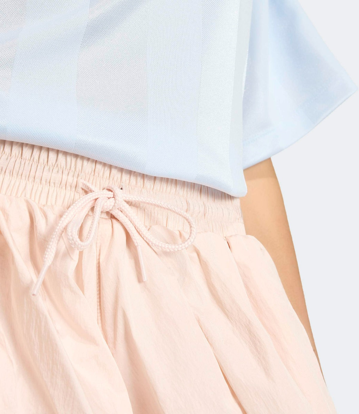 חצאית קיץ נשית בגוון ורוד בהיר עם שרוך במותן, מבד קל ונוח, מוצגת על דוגמנית