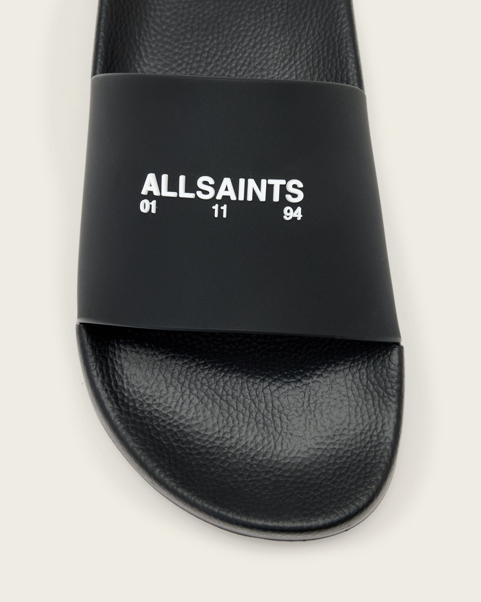 כפכף שחור עם רצועה רחבה, כיתוב ALLSAINTS בלבן על הרצועה