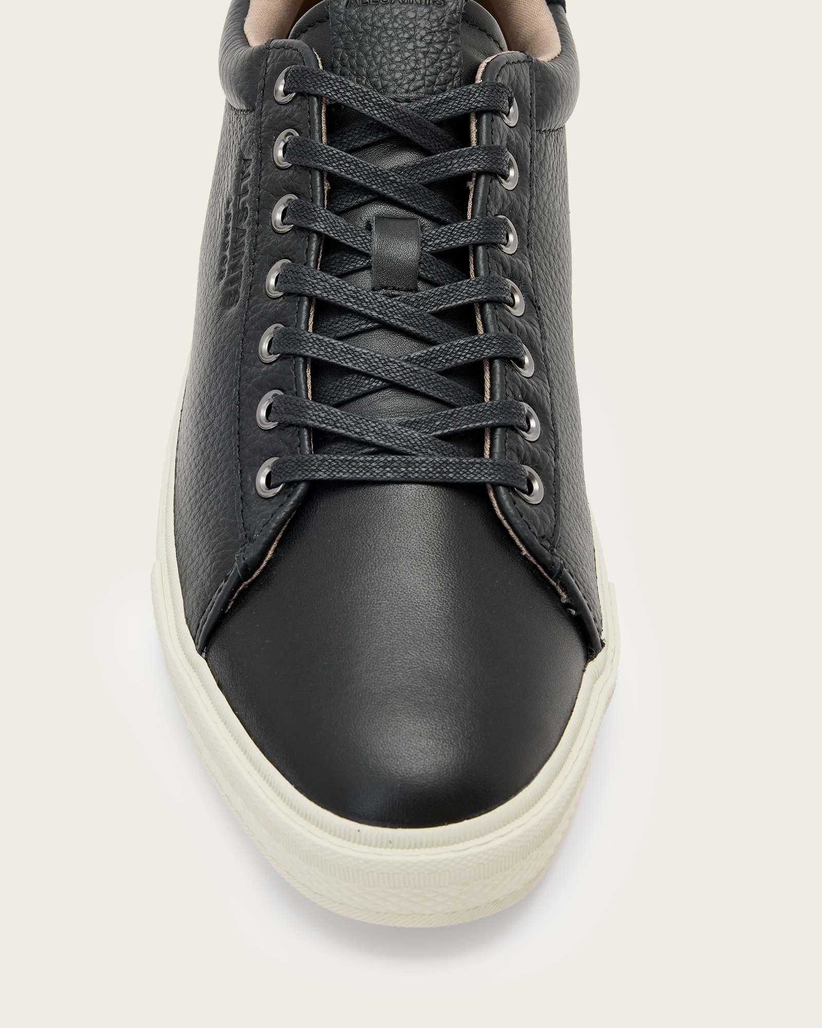 סניקרס עור שחורות לגבר עם שרוכים וסוליה לבנה, נראים מלמעלה, נעל אופנתית קלאסית