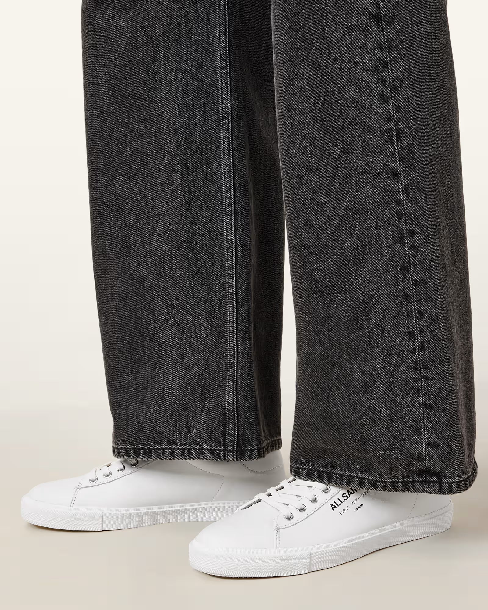 מכנסי ג'ינס שחורים רחבים עם סניקרס לבנים שטוחים, עיצוב יומיומי אופנתי