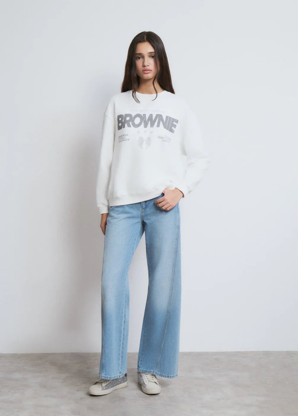 דוגמנית עם סווטשרט לבן BROWNIE וג'ינס רחב, אופנת נשים בקולקציה של CHOZEN