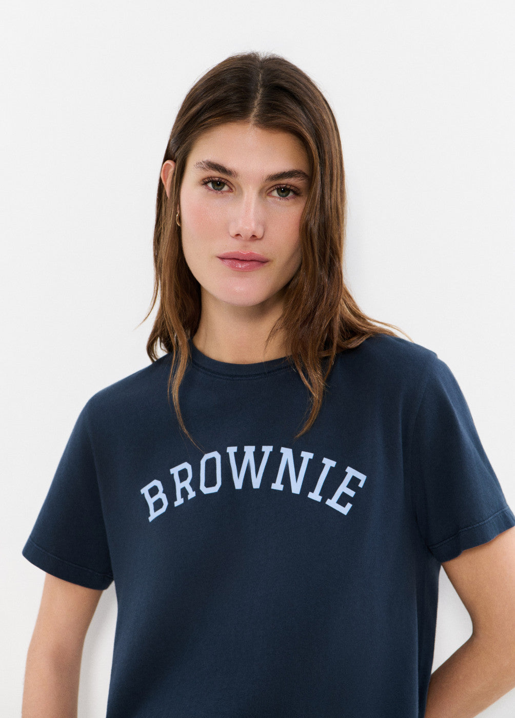 אישה לובשת חולצת טי כחולה עם הדפס BROWNIE, צילום אופנה על רקע לבן