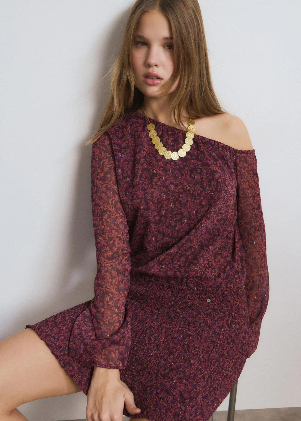 אישה בשמלה בורדו עם דוגמת פרחים, שרשרת זהב, אופנה לנשים CHOZEN