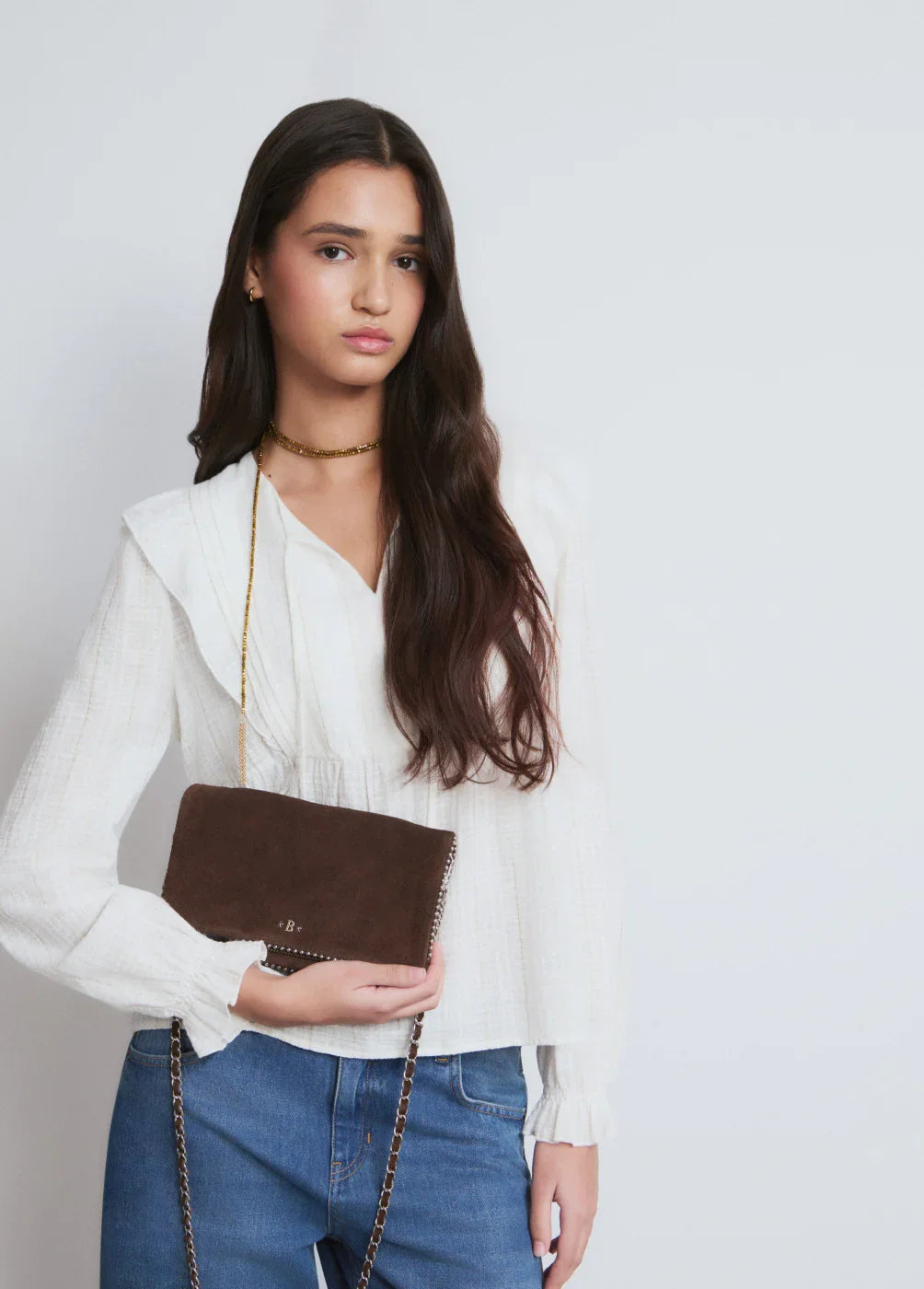 אישה לובשת חולצה לבנה ומחזיקה תיק כתף חום אופנתי, אופנה עדכנית CHOZEN