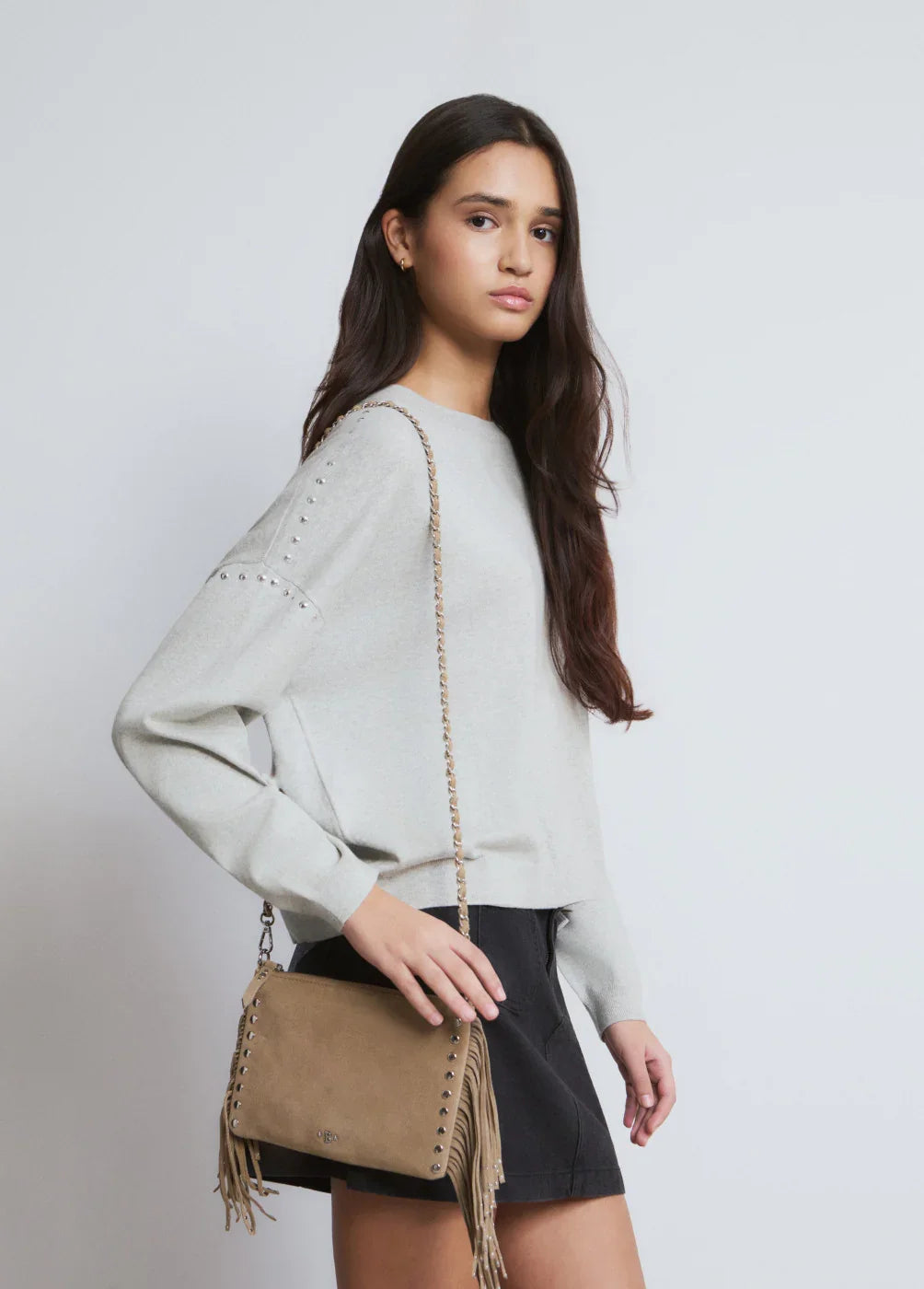 דוגמנית עם סוודר אפור, תיק צד חום עם פרנזים, אופנה לנשים CHOZEN