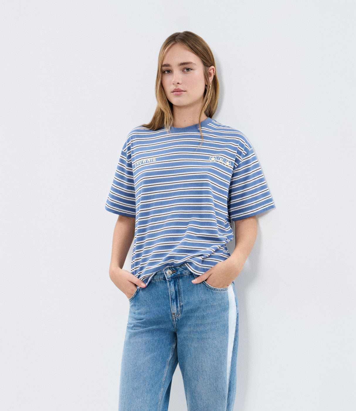 אישה עם חולצת פסים כחולה ולבנה ומכנסי ג'ינס, אופנת קז'ואל