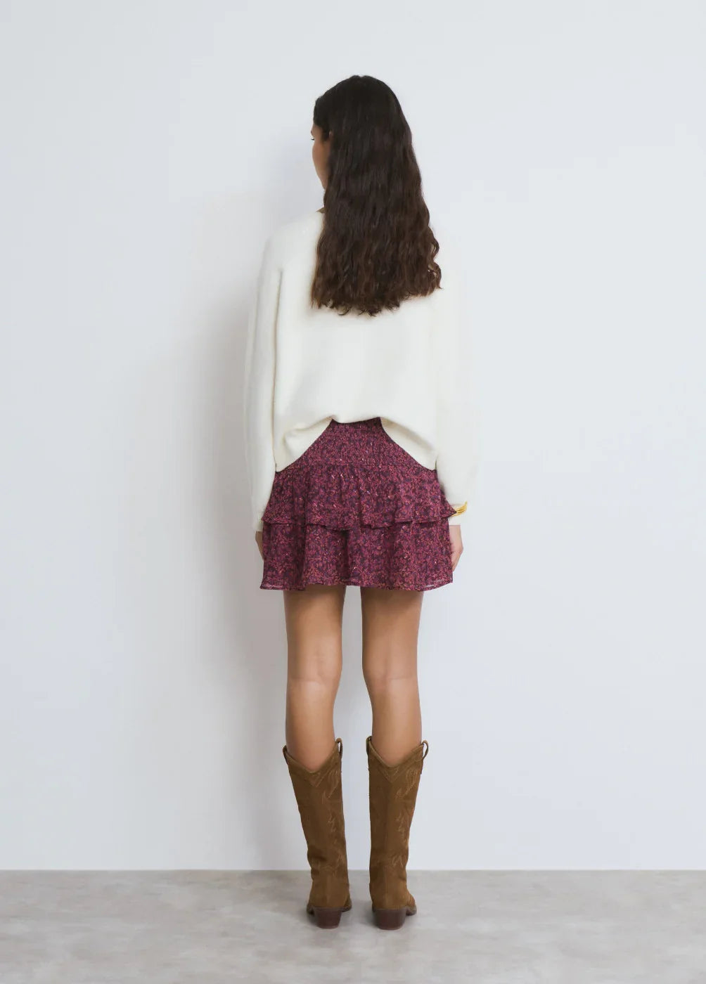 דוגמנית עם סוודר לבן, חצאית שכבות פרחונית ומגפי עור חומים, צילום אופנה ל-CHOZEN