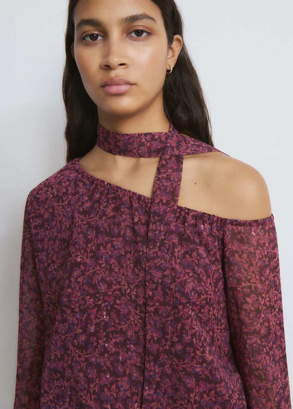 אישה לובשת חולצת כתף חשופה בצבע בורדו עם דוגמת פרחים, אופנה יוקרתית מבית CHOZEN