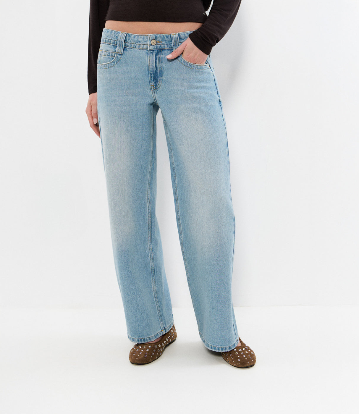 ג'ינס נשים בגזרה רחבה בצבע תכלת, חולצה שחורה ארוכה ונעלי מוקסין חומות