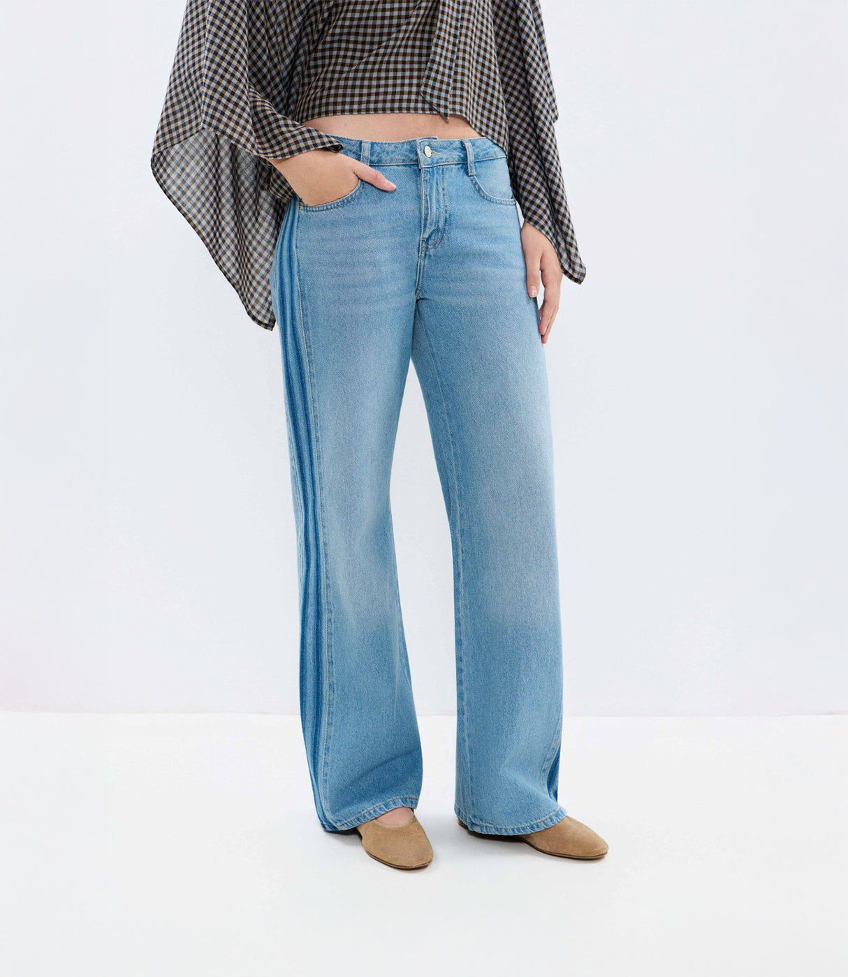 ג'ינס בגזרה רחבה בצבע תכלת לנשים, משולב עם חולצה משובצת ונעליים שטוחות