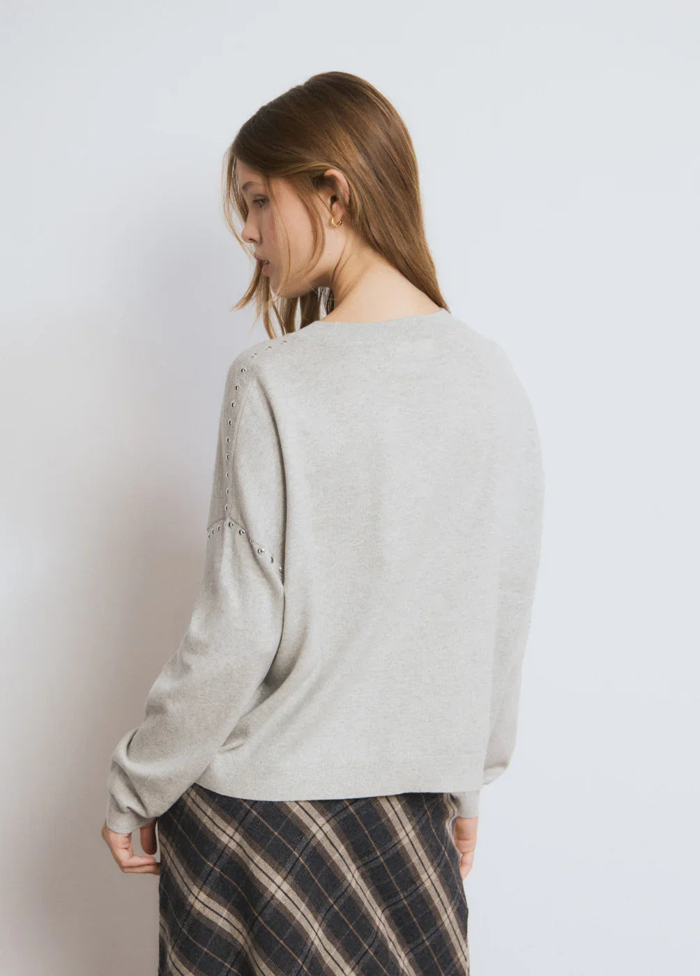 דוגמנית עם סוודר אפור משוחרר וחצאית משובצת, אופנת נשים CHOZEN