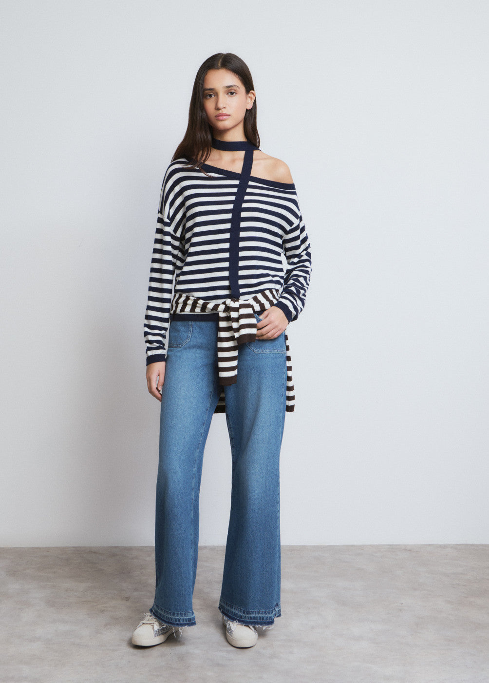 אישה עם סוודר פסים כחול-לבן וג'ינס רחב, אופנה קז'ואל עכשווית