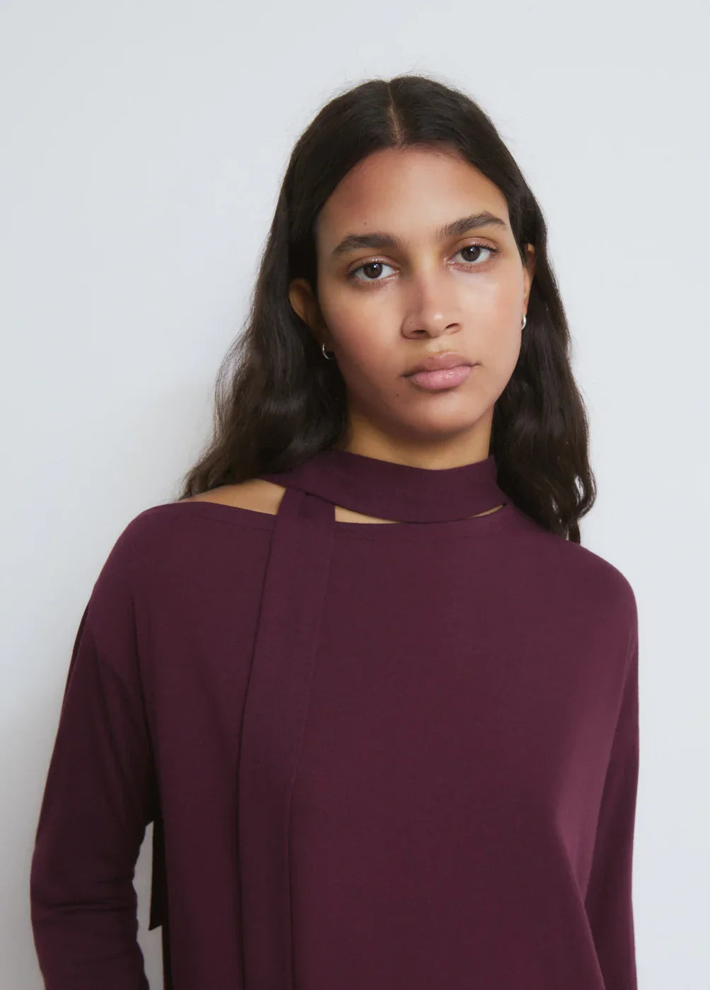 דוגמנית עם חולצה בורדו עם סרט צוואר, צילומי אופנה של מותג CHOZEN