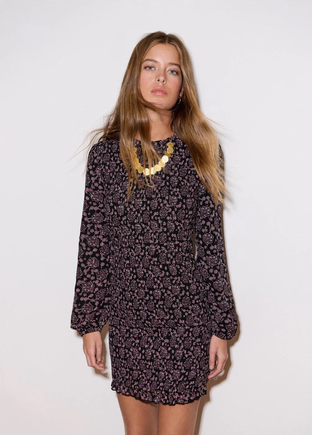 דגם לבוש בשמלת מיני שחורה עם דוגמת פרחים סגולים ושרשרת זהב, אופנת נשים CHOZEN