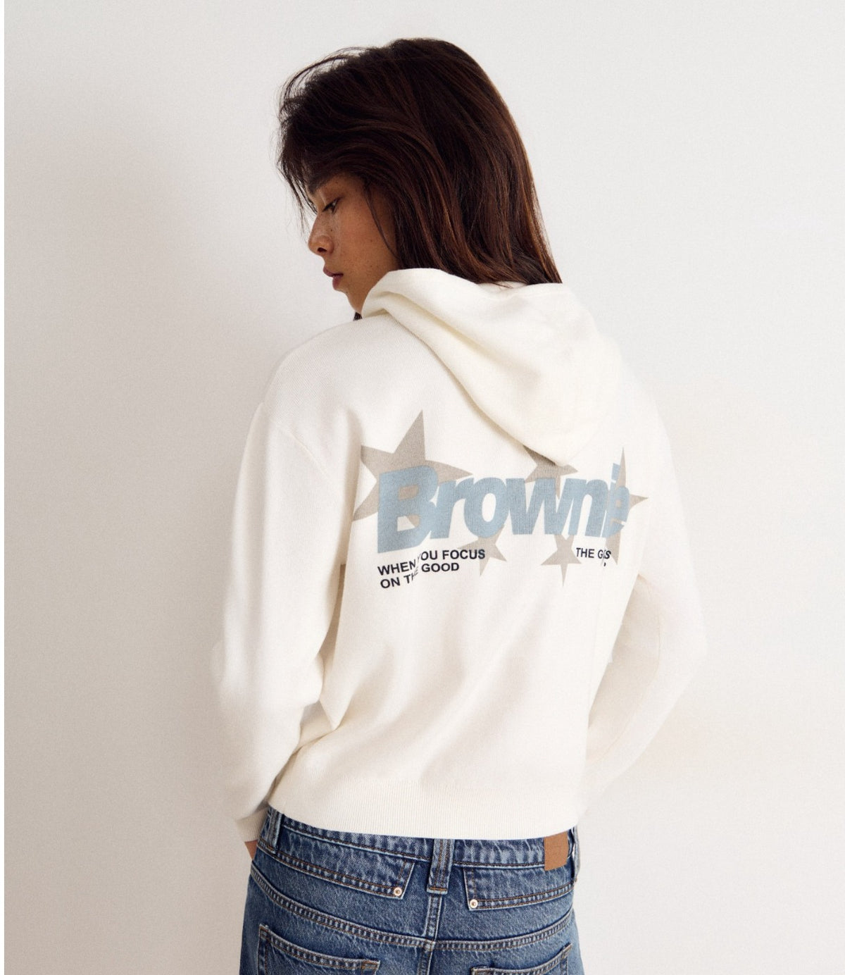 דוגמנית מצולמת מהגב עם הדפס Brownie על הברדס הלבן - CHOZEN